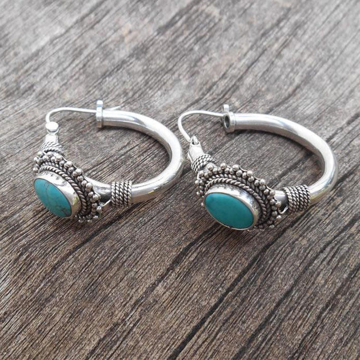 Elegante zilverkleurige oorbellen met turkooiskleurige steen