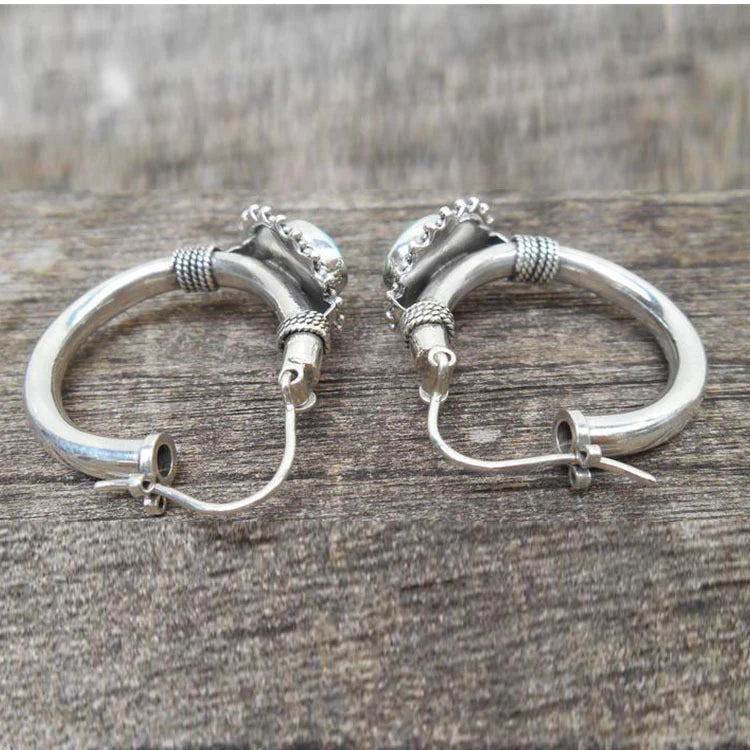 Elegante zilverkleurige oorbellen met turkooiskleurige steen